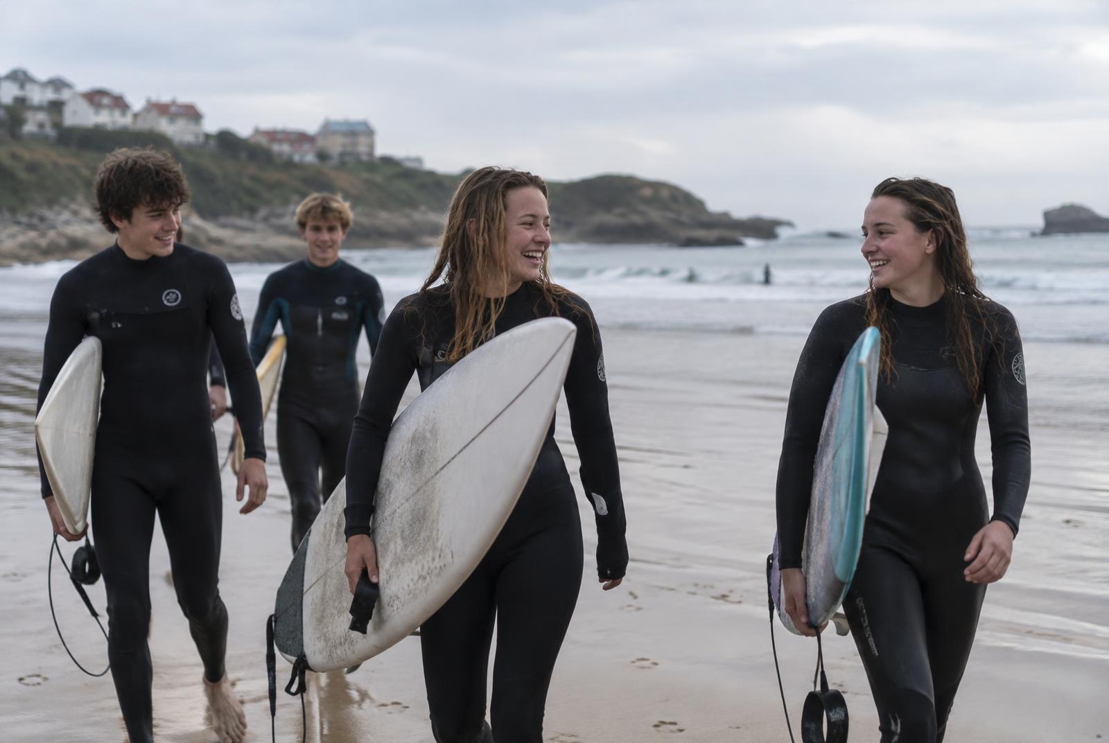 Groupe de jeunes réunis sur la plage au coucher du soleil